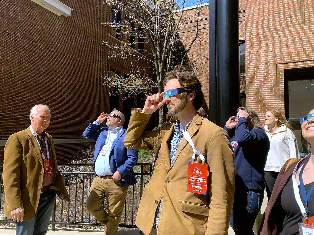 Matthew DeFour, Wisconsin Watch’s statehouse bureau chief, watches the April 8, 2024, eclipse outside the Miller High Life Theatre in downtown Milwaukee. (Jack Kelly / Wisconsin Watch)